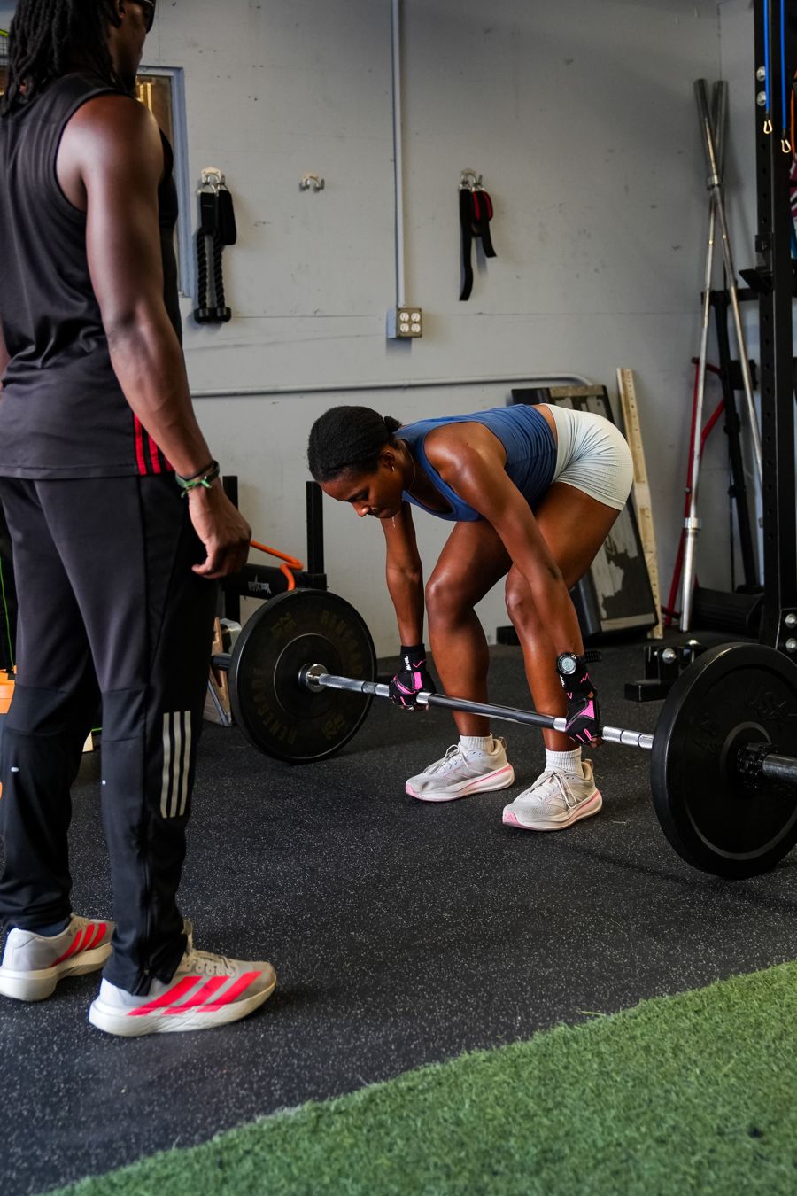 Coach watching an athlete set up a barbell deadlift